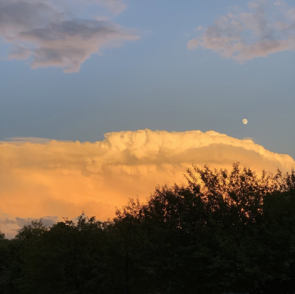 Moon and clouds over sunset sky in New Mexico landscape